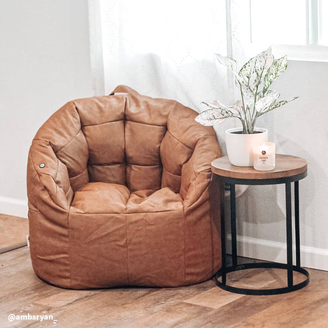 brown massage bean bag chair with a side table in a apartment
