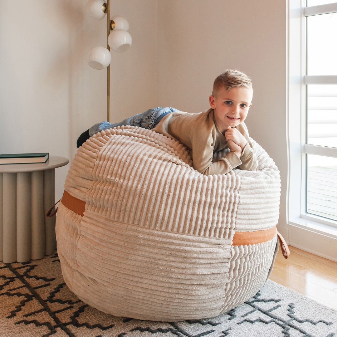 Young Boy Relaxing on Youth Bean Bag Chair #color_vanilla-latte-corded-plush