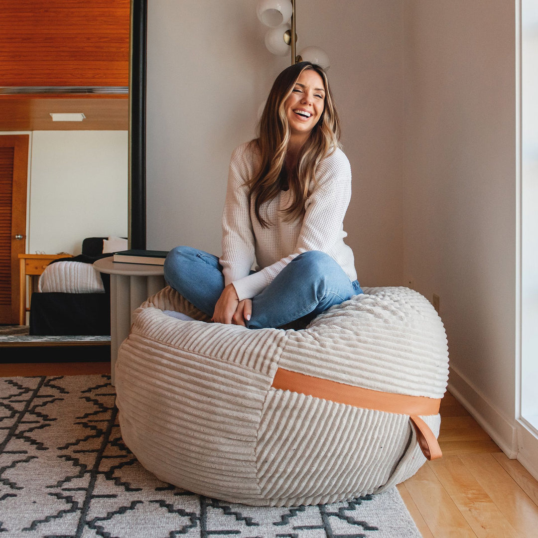 Woman sitting on Medium Fuf Bean Bag Chair in Vanilla Latte Corded Plush #color_vanilla-latte-corded-plush