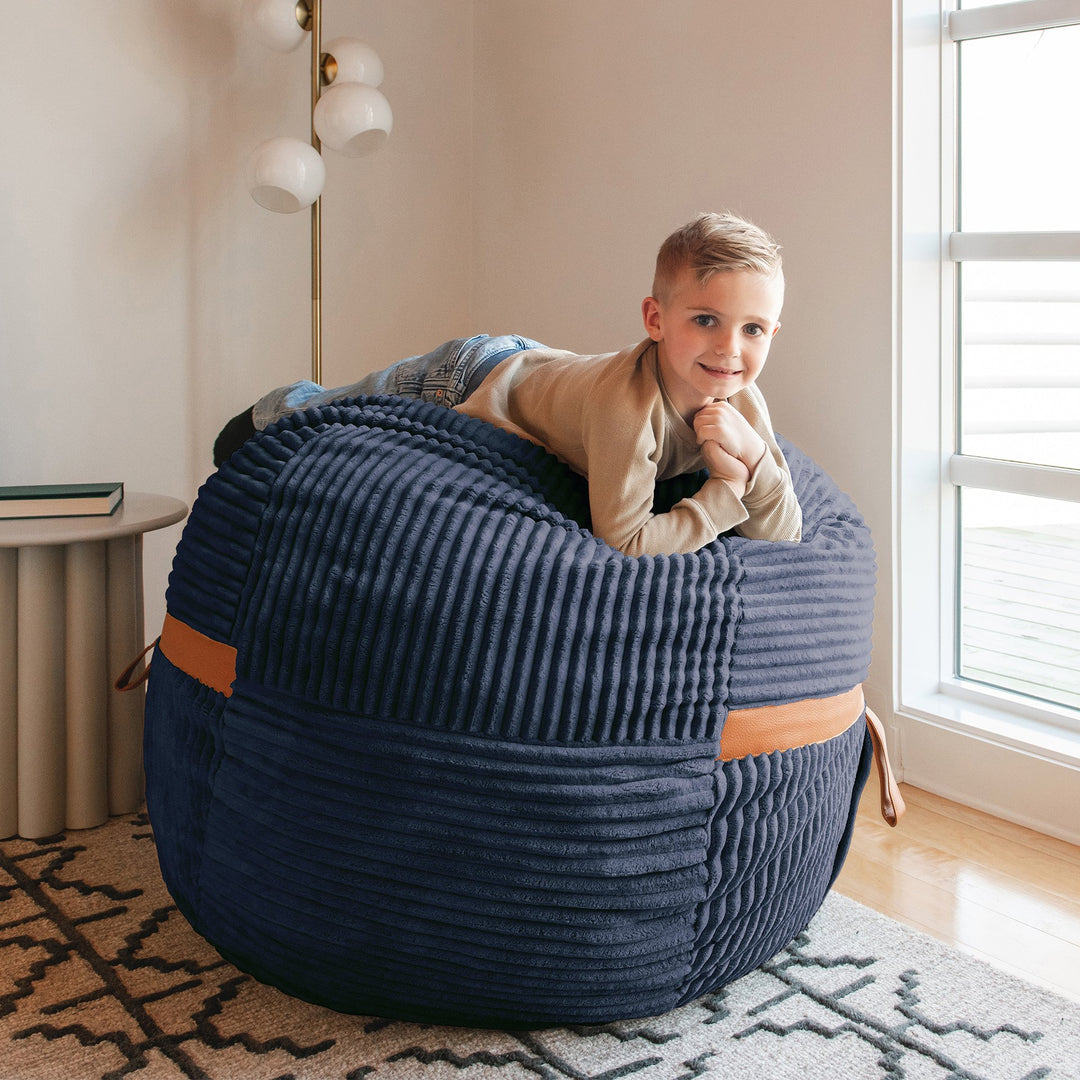 boy laying on Fuf Medium Foam-Filled Bean Bag Chair #color_midnight-blue-corded-plush