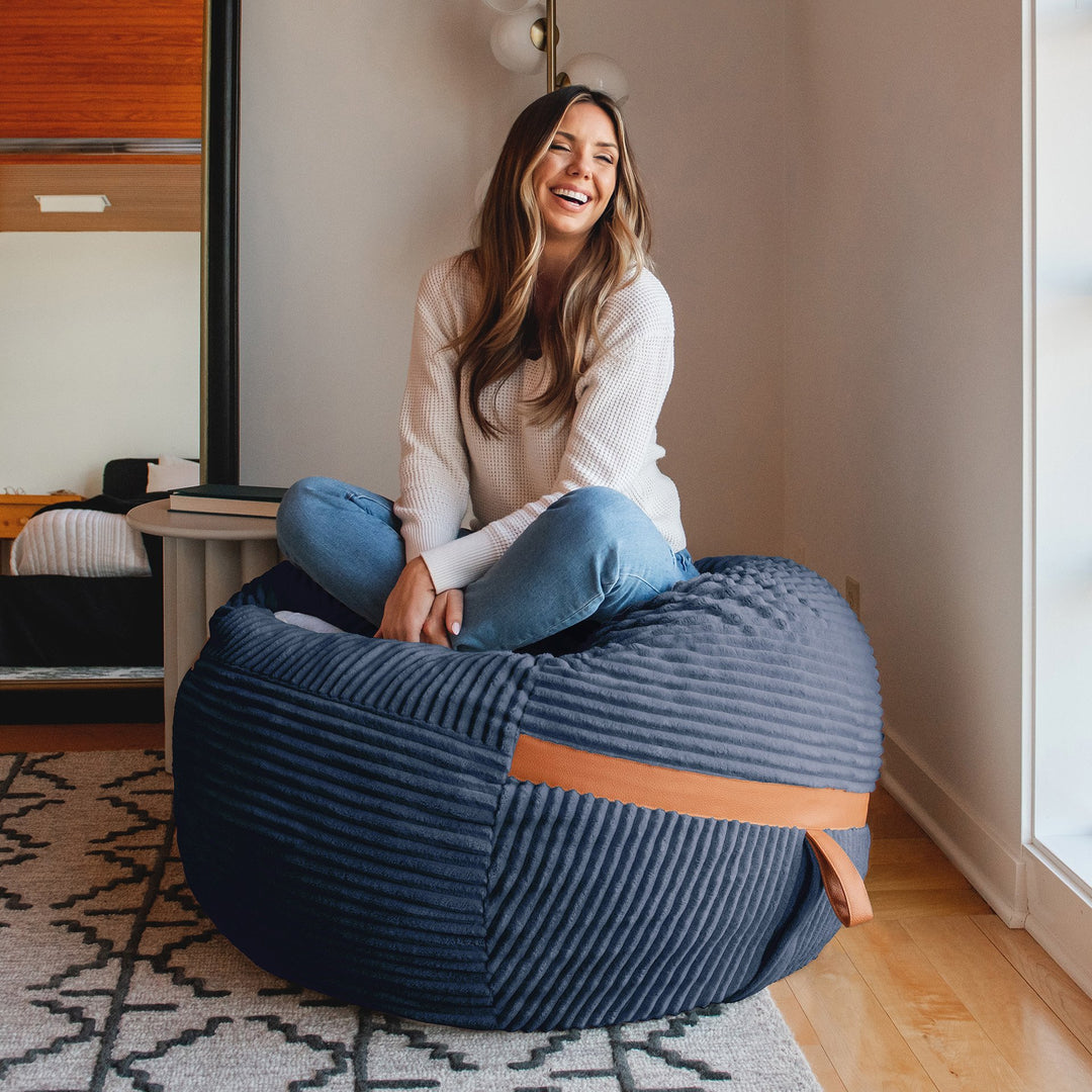 woman sitting on Fuf Medium Foam-Filled Bean Bag Chair #color_midnight-blue-corded-plush