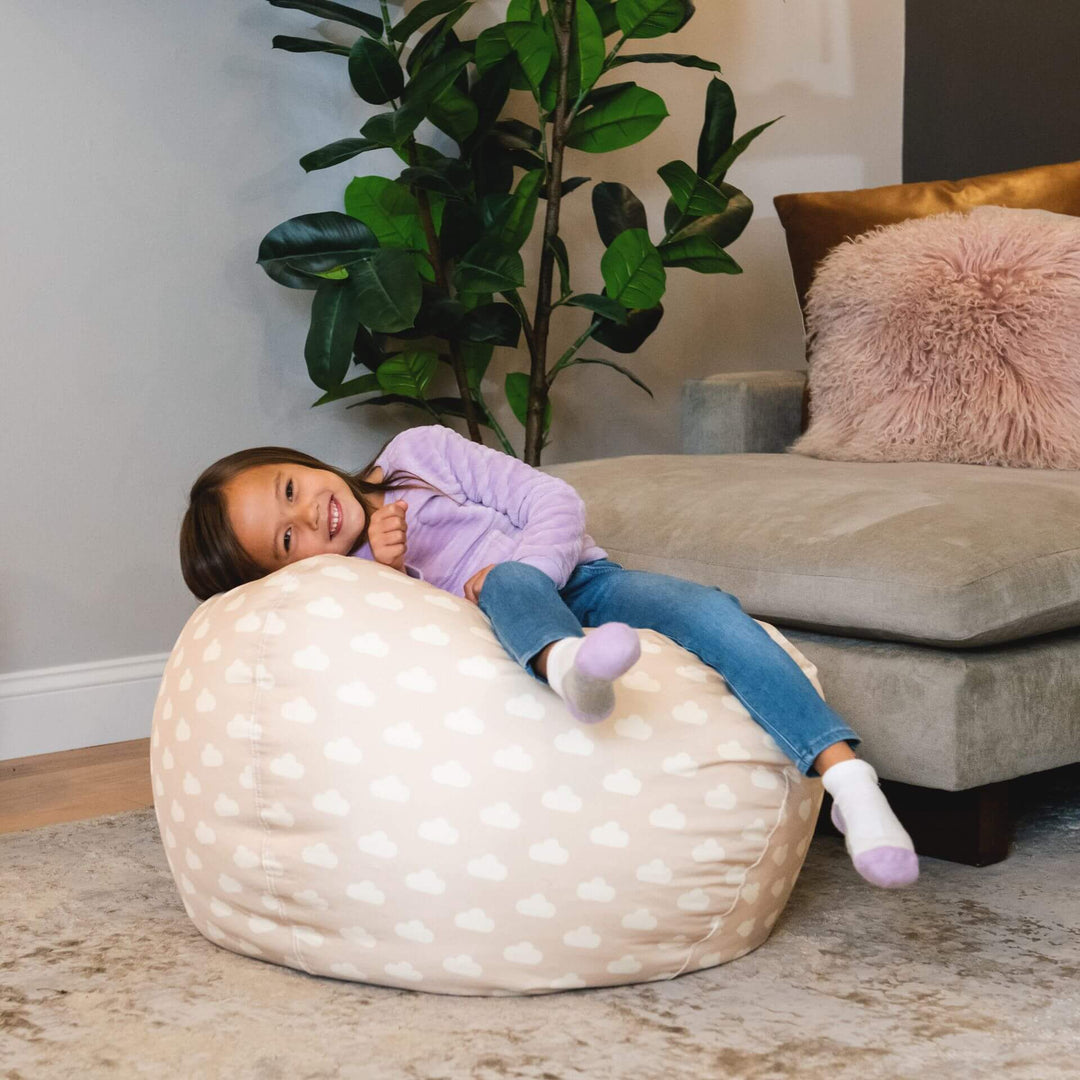 Girl laying on kids bean bag chair polka dot oat colored #color_mini-clouds-oat-smartmax