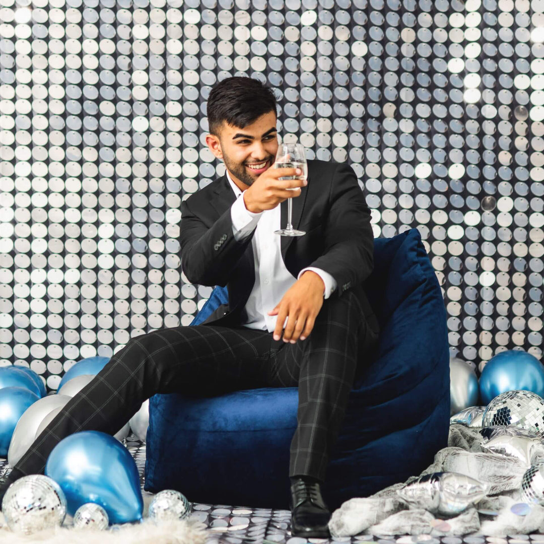 Aurora Chair bean filled man at party #color_deep-navy-velvet