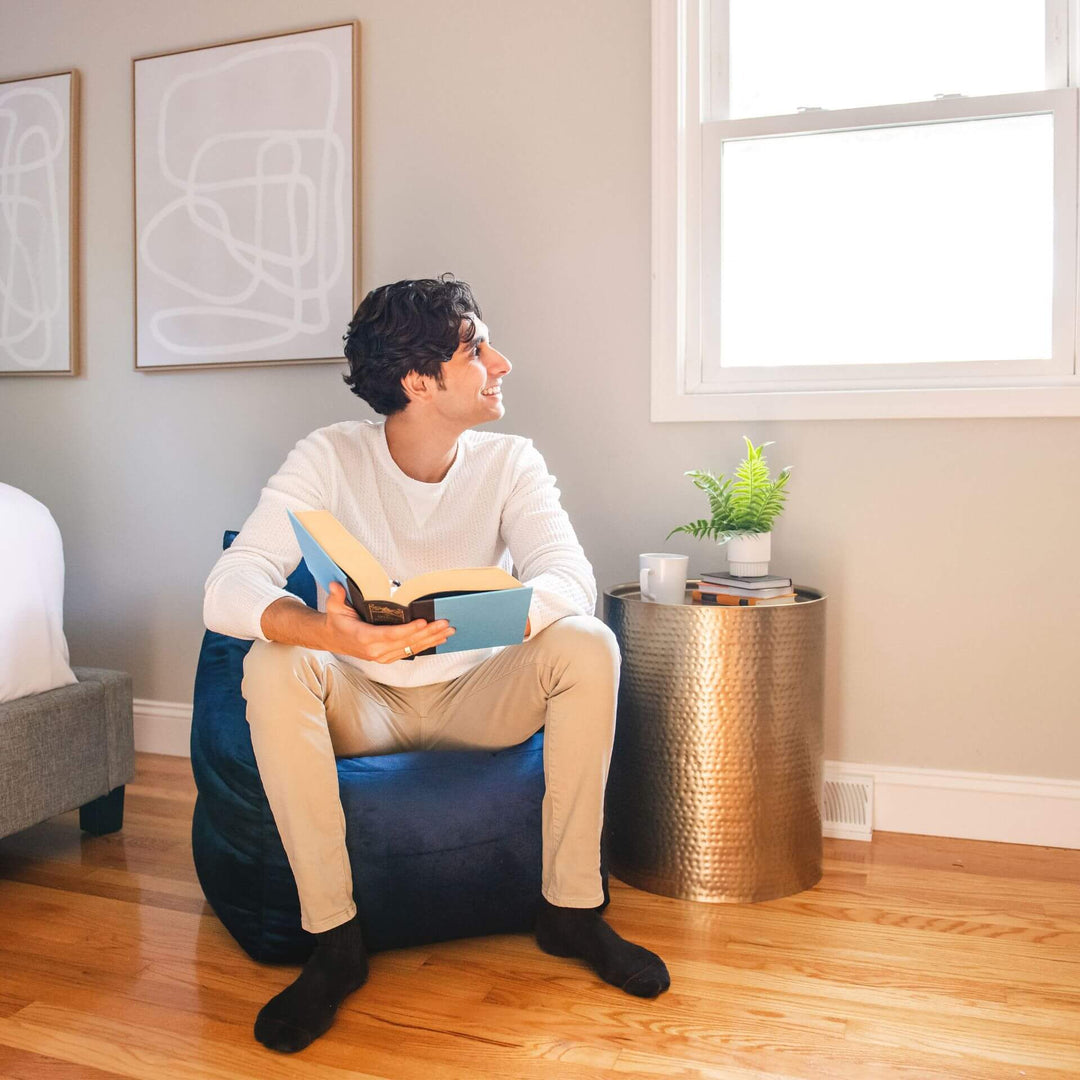 Aurora Bean Bag Chair man reading #color_deep-navy-velvet