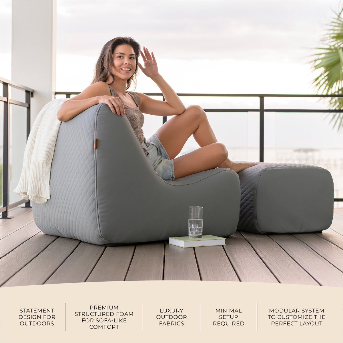 Woman relaxing on a modern outdoor sofa with a view of a balcony and ocean.