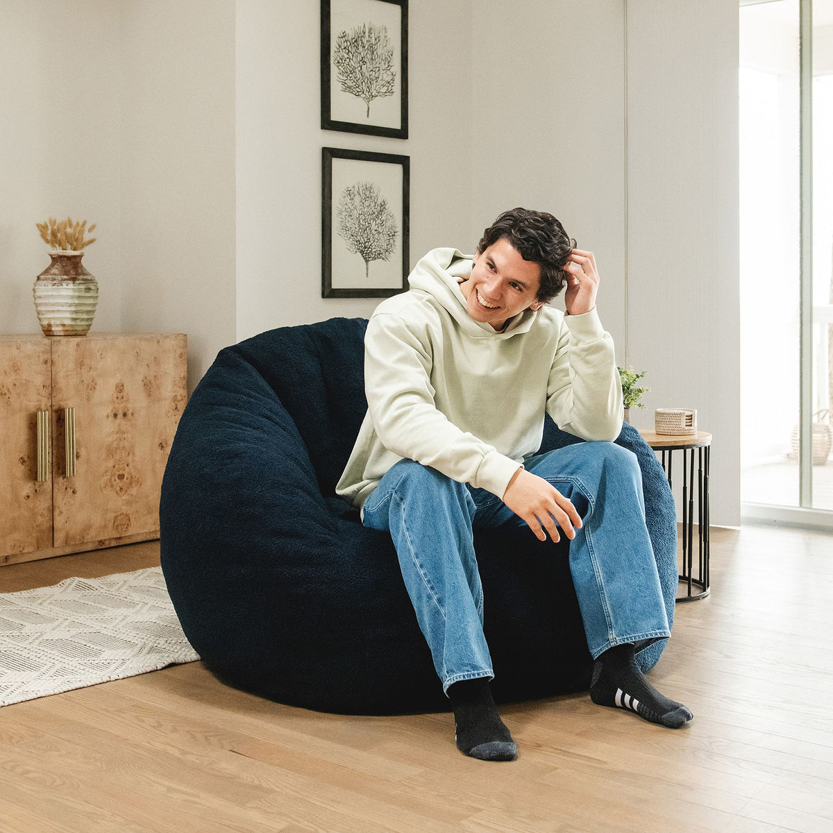 Man sitting in a blue cloud-like chair in the living room