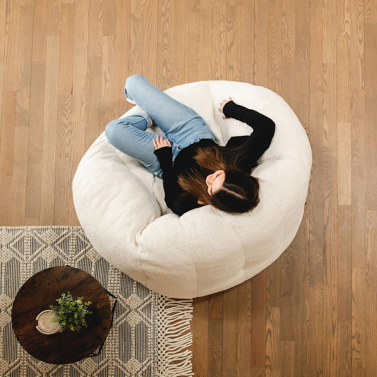White foam chair in living room picture taken from above with girl sitting in chair