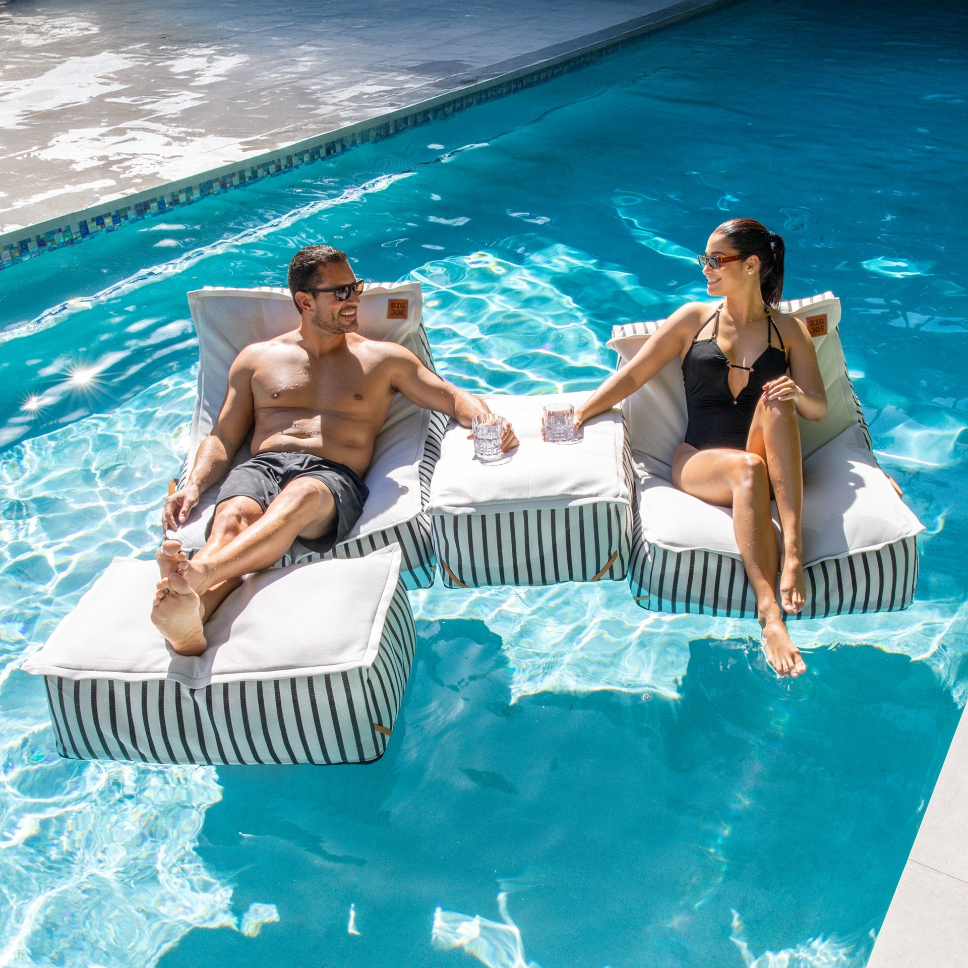Lux sealander pool lounger couple floating in pool #color_black-and-white-cape-stripe