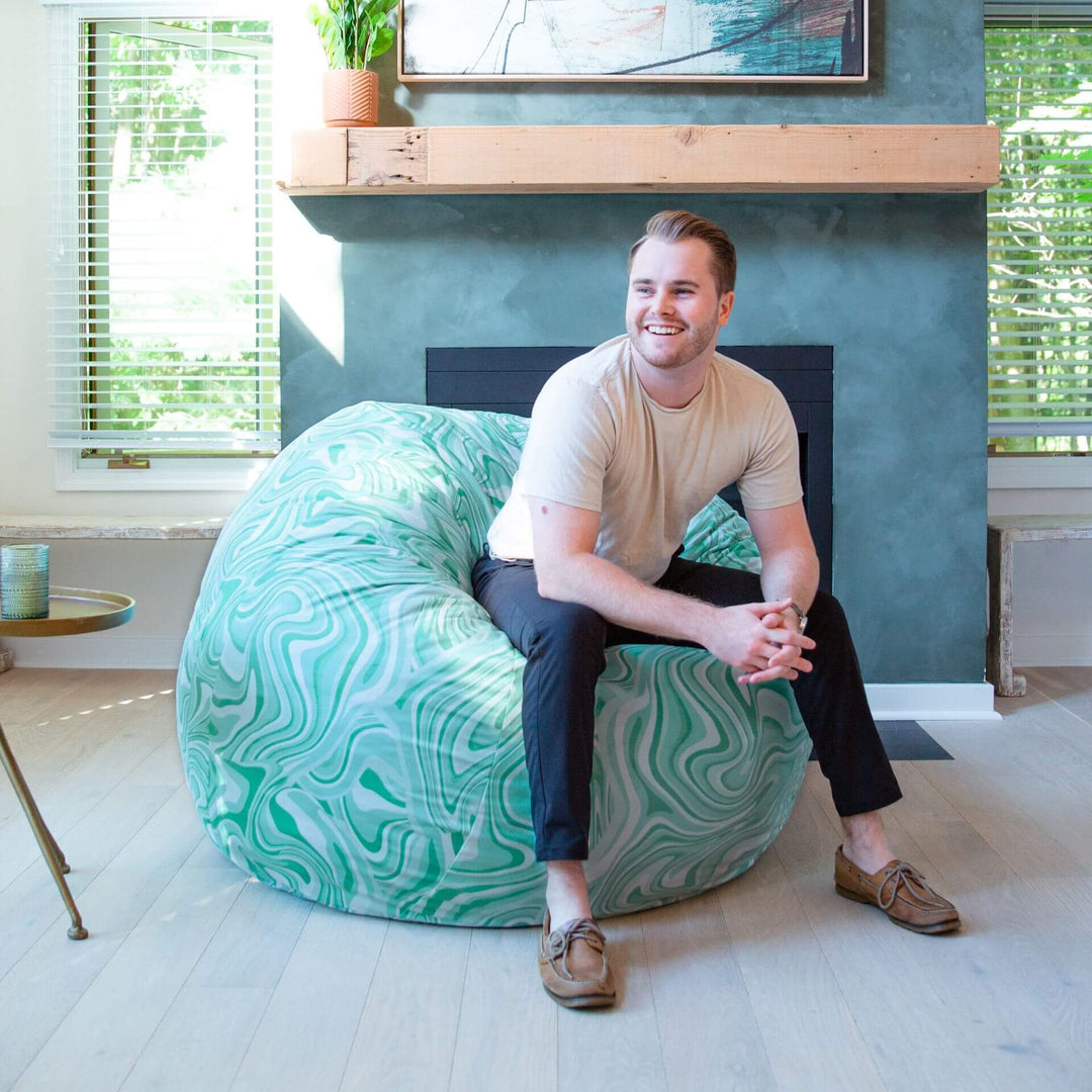Man on beanbag chair Retro foam filled bag chair #color_groovy-green-plush