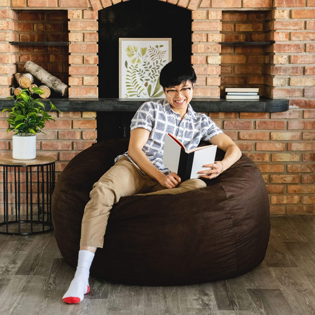 Reading on large brown Fuf beanbag foam chair #color_cocoa-brushed-denim