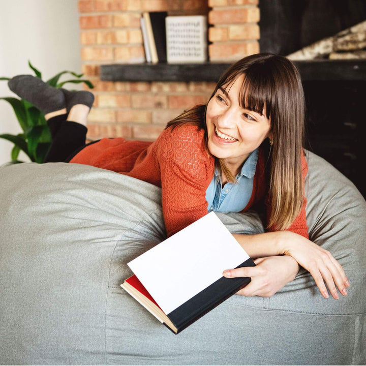 Woman relaxing on Fuf gray foam filled beanbag chair #color_fog-lenox