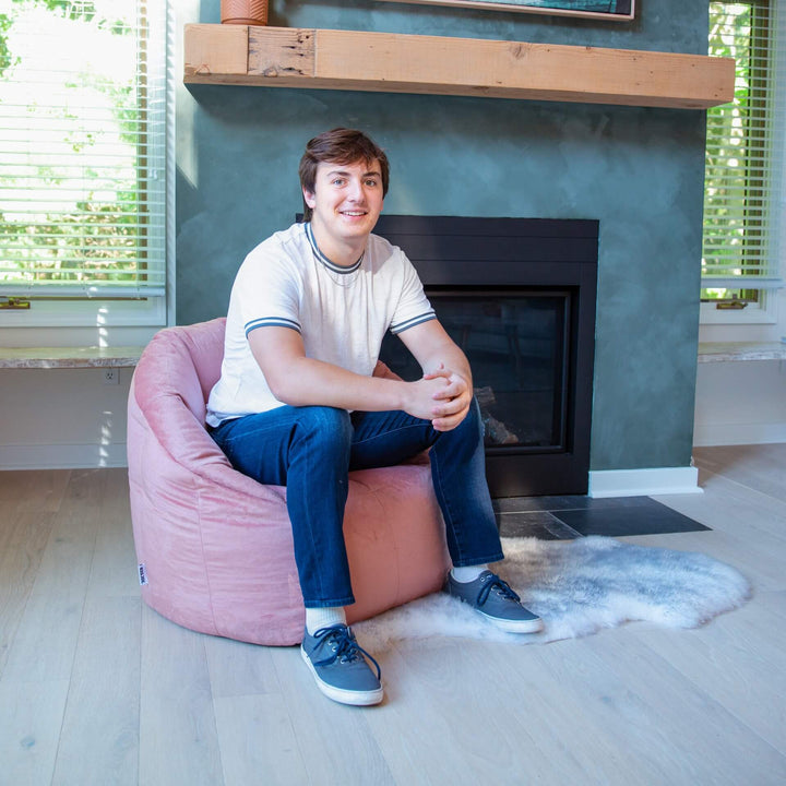 Milano Adult Beanbag Chair man relaxing in living room #color_desert-rose-plush