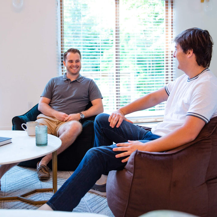Men relaxing on hug beanbag chairs #color_cocoa-plush