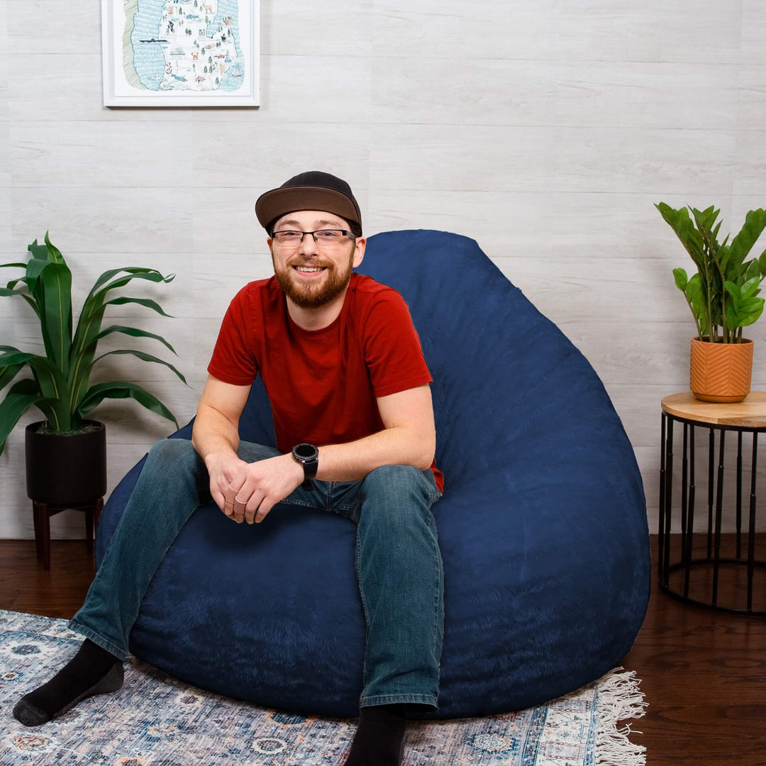 Man on lotus blue teardrop shaped foam beanbag #color_navy-short-shag