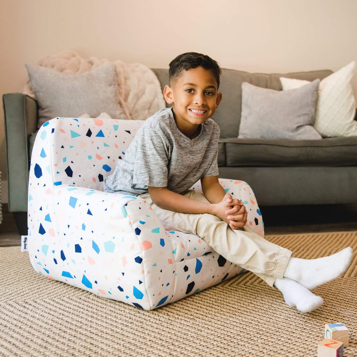 Kids chair Mid-Mod boy relaxing in living room #color_dolce-terrazzo-lenox