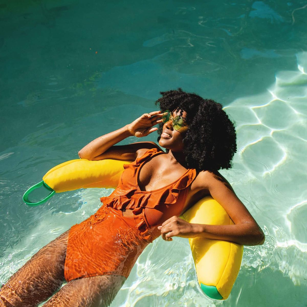 Woman floating on Banana pool noodle float