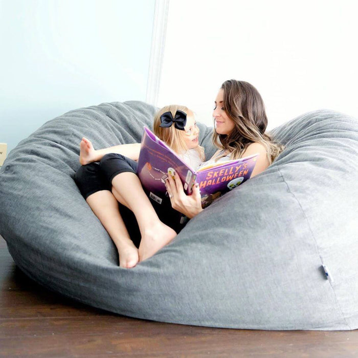 Mother and daughter sitting in a large bean bag chair reading