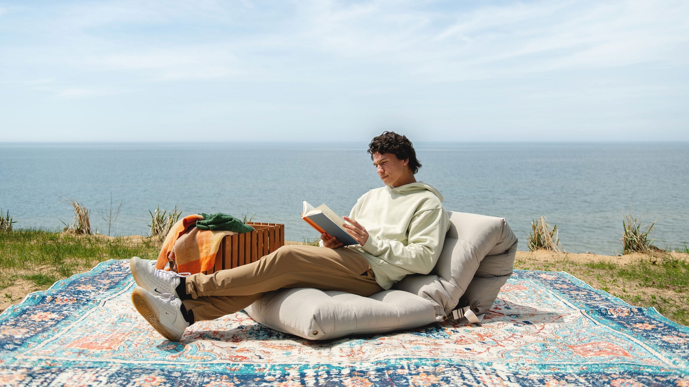 Man relaxing outdoors on the Chameleon Convertible bean bag lounger.