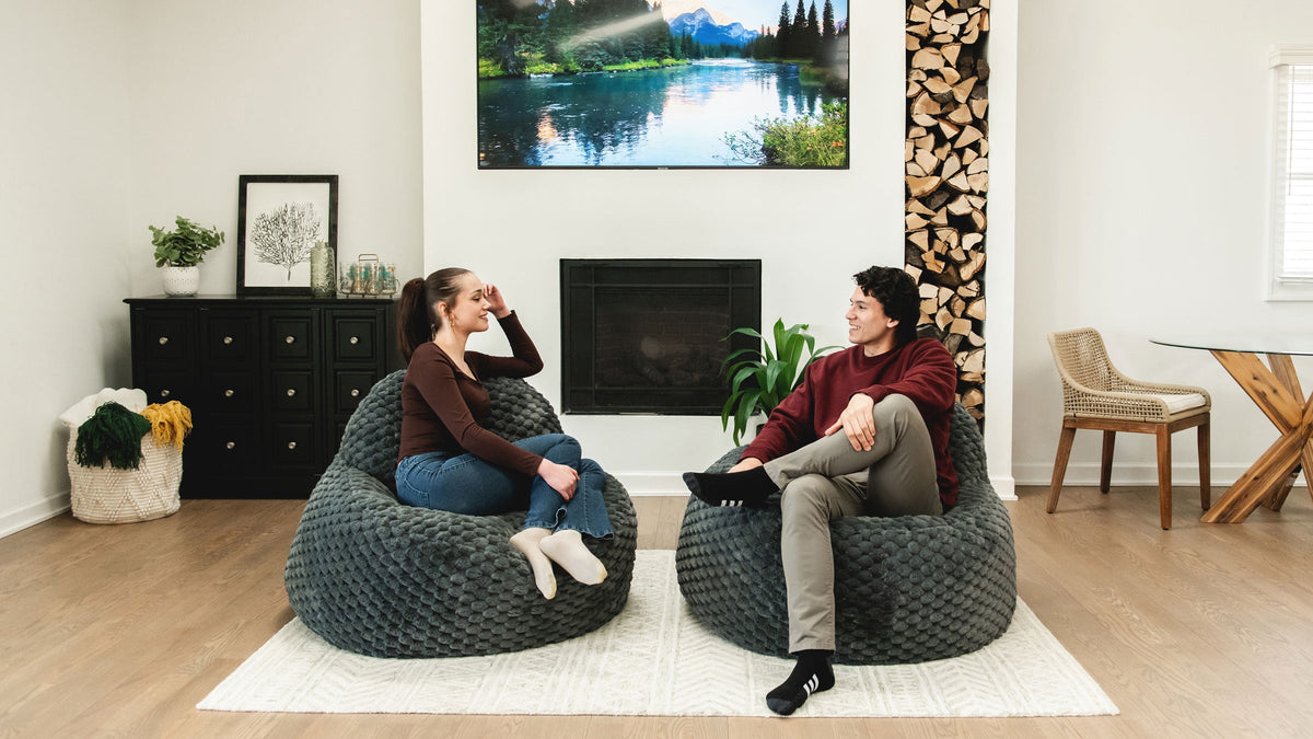 Couple sitting on bean bag chairs in the living room having a conversation