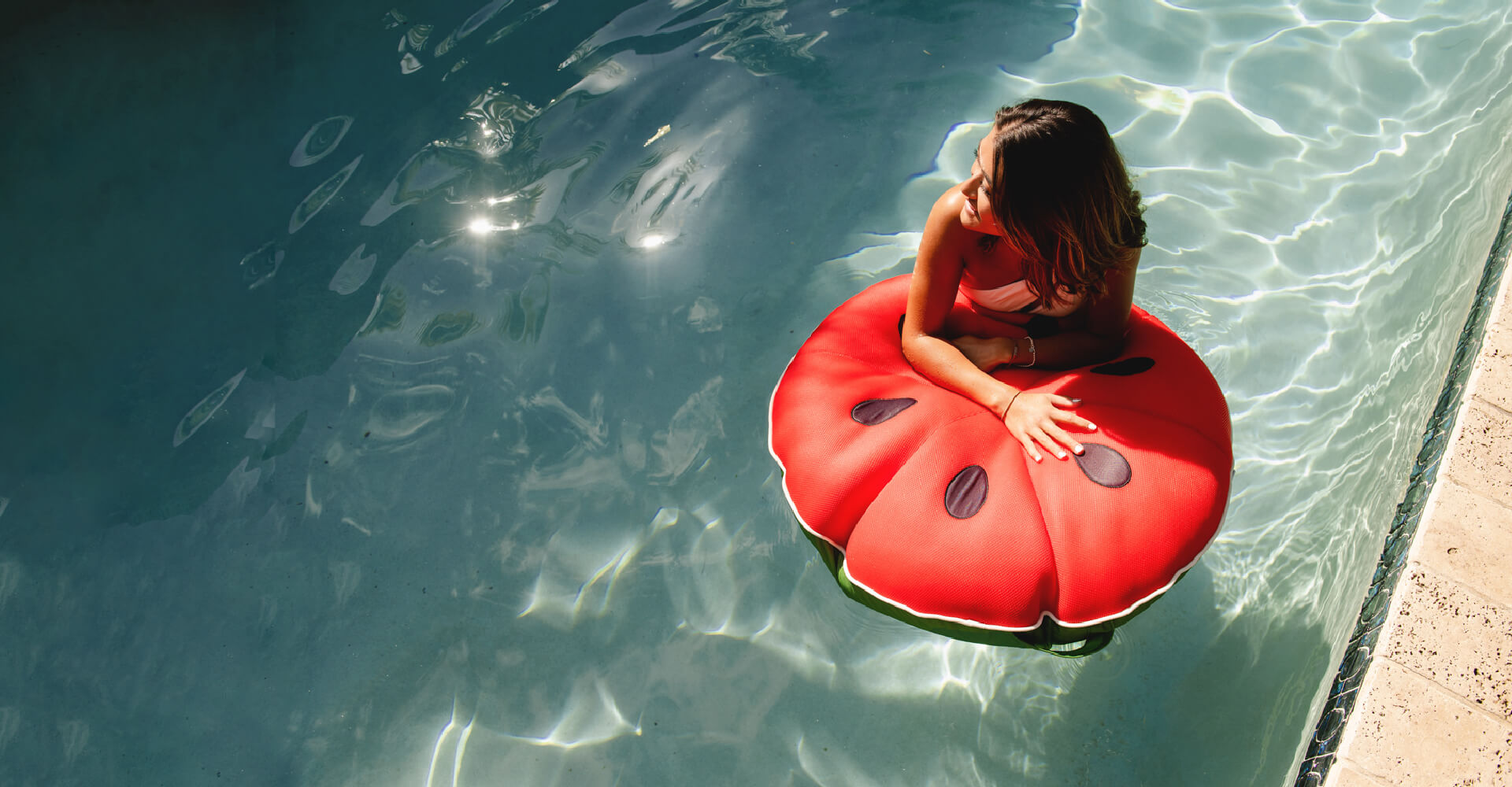 Woman in the pool floating on the watermelon float