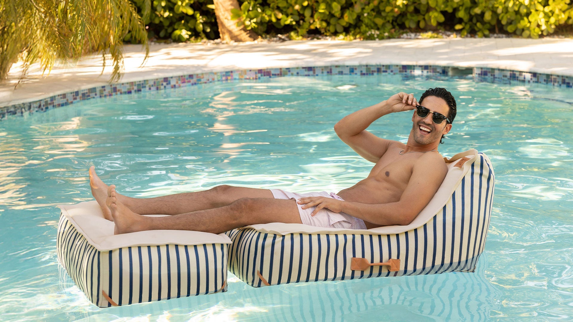 Man relaxing on the Lux Sealander pool float in the pool