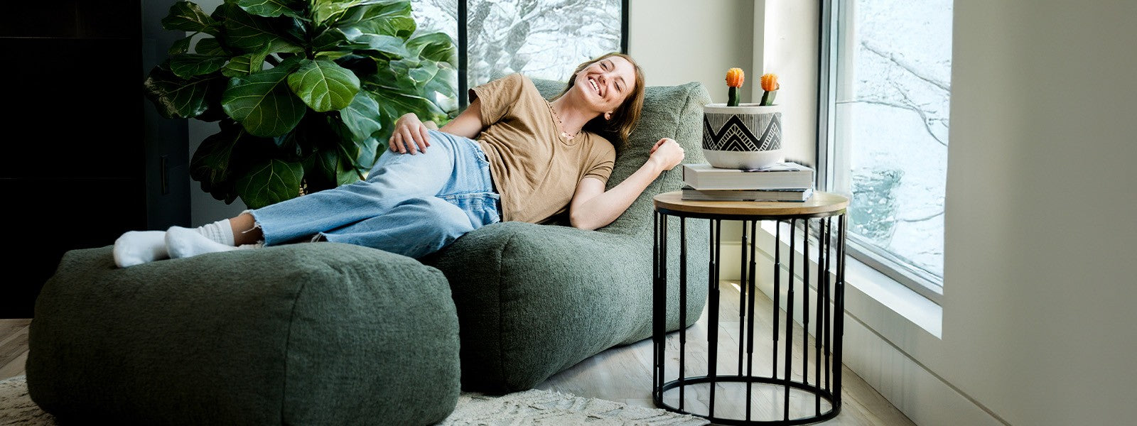 Woman laying on the Modora chair and ottoman in the living room