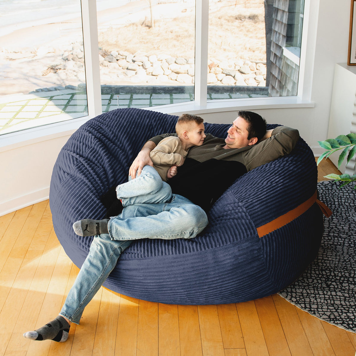 Father and Son relaxing on Big Joe Fuf XL Foam Beanbag Lounger Midnight Blue Corded Plush #color_midnight-blue-corded-plush