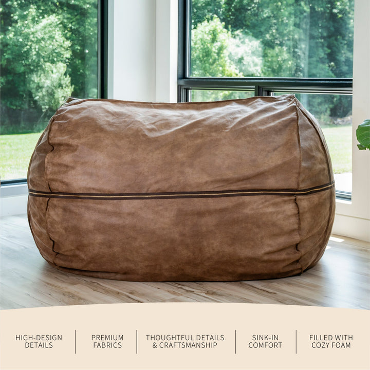 Brown bean bag chair in a room with large windows showing greenery #color_coffee-soft-vegan-leather