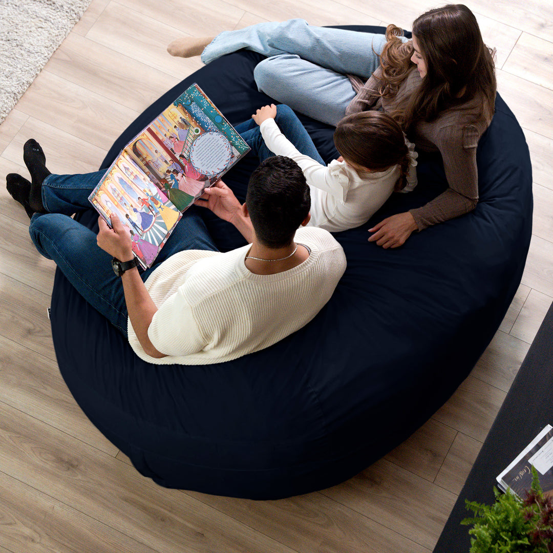 Family sitting on a bean bag reading a book together #color_cobalt-brushed-denim