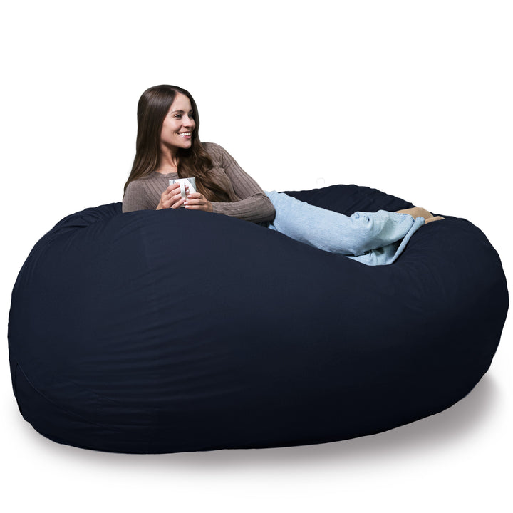 Woman sitting on a large navy bean bag chair holding a mug. #color_cobalt-brushed-denim