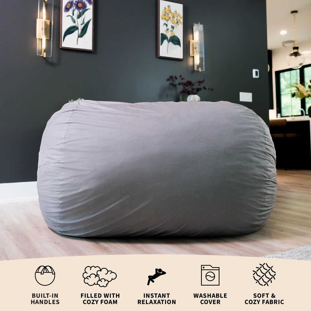 Gray bean bag chair in a room with dark walls and framed pictures. #color_fog-brushed-denim