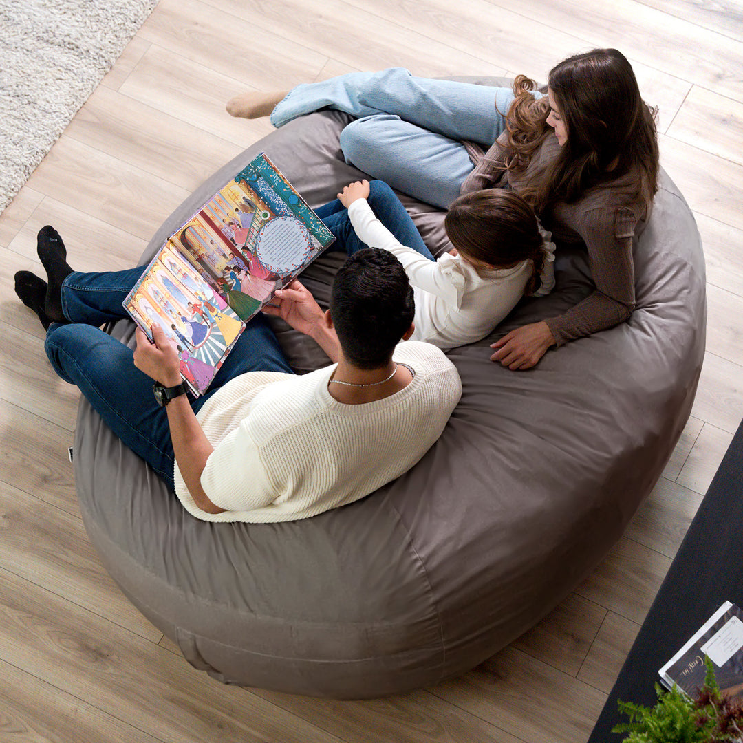 Family reading a book together on a large bean bag chair. #color_fog-brushed-denim