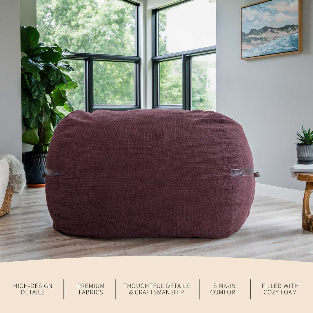 Maroon bean bag chair in a room with large windows and plants #color_merlot-cloudweave