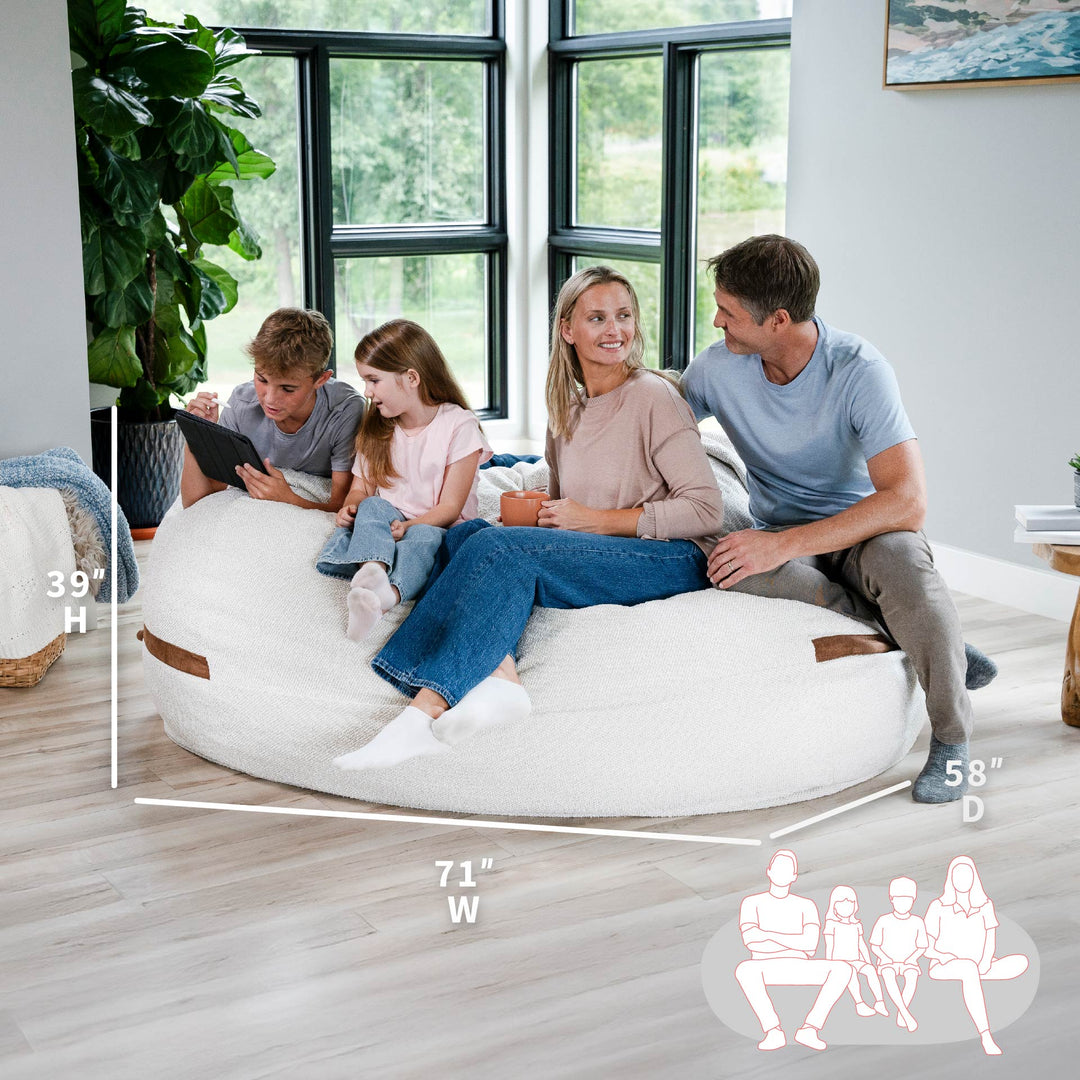 Family sitting on a bean bag chair with dimensions displayed #color_sandstone-textured-boucle