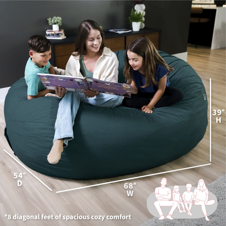 Three children sitting on a large teal bean bag reading a book, with measurements displayed. #color_deep-sea-velveteen