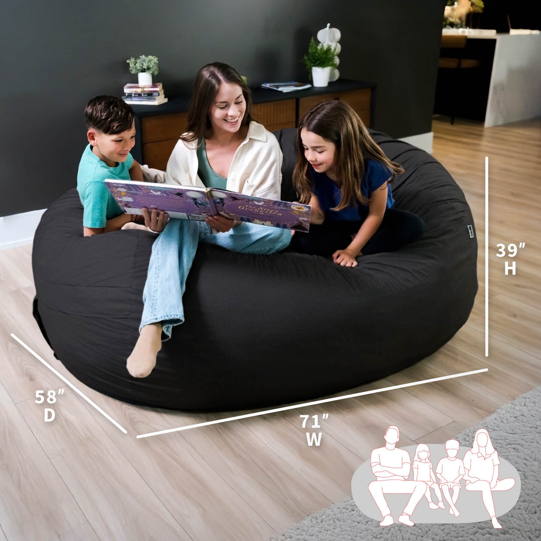 Family reading together on a large black bean bag with measurements displayed. #color_black-brushed-denim