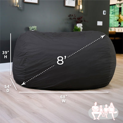 Black bean bag chair with dimensions on a wooden floor. 