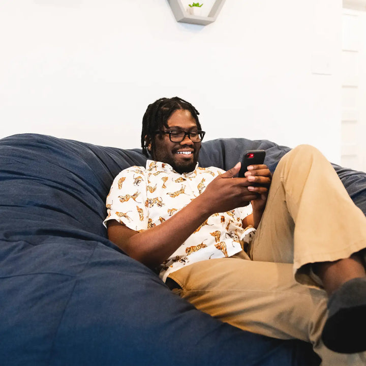 Fuf XXL Giant Bean Bag Chair man relaxing watching phone #color_cobalt-lenox