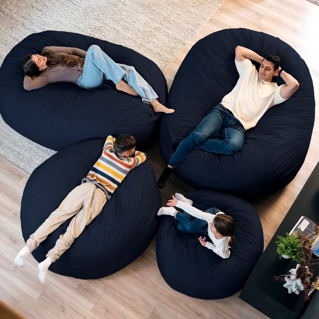 Four people relaxing on navy bean bags in a living room. #color_cobalt-brushed-denim
