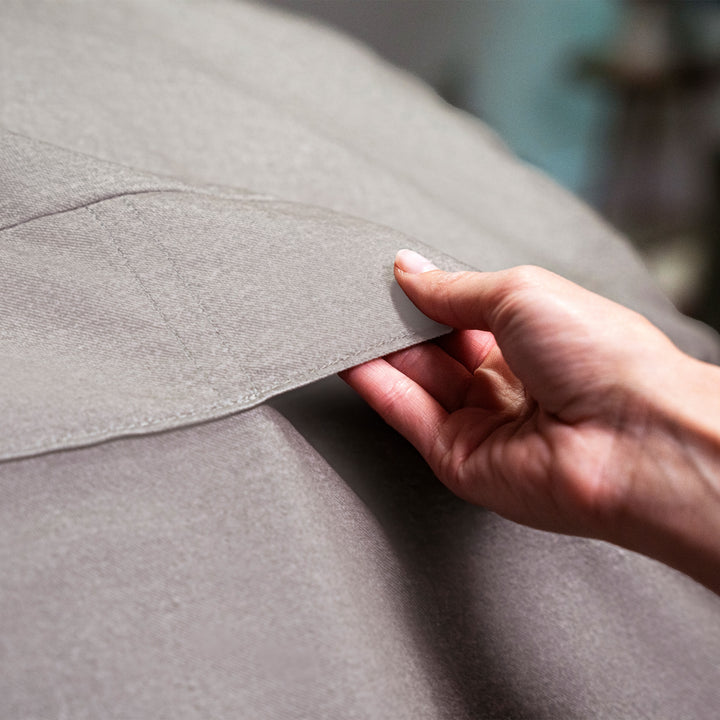 Hand touching a gray fabric surface #color_fog-brushed-denim