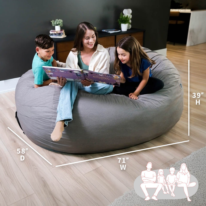 Family reading together on a large gray bean bag with dimensions displayed. #color_fog-brushed-denim
