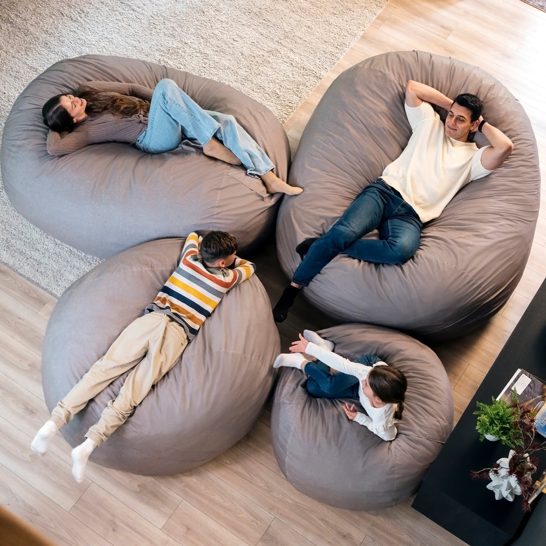 Four people relaxing on large bean bags in a living room. #color_fog-brushed-denim