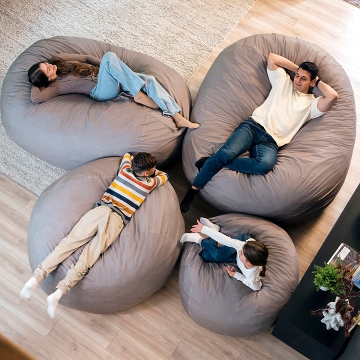 Four people relaxing on large bean bags in a living room. #color_fog-brushed-denim