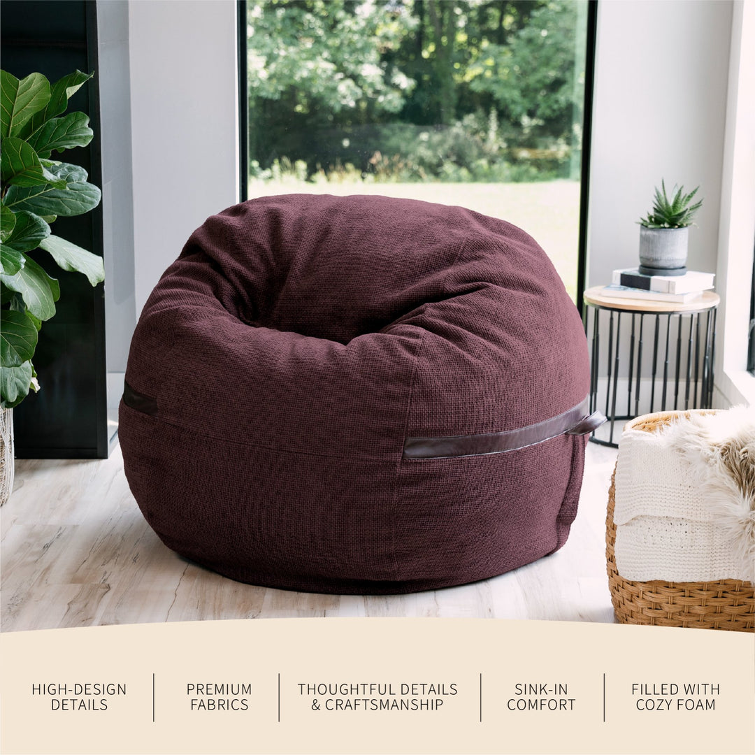 Maroon bean bag chair in a room with plants and a window. #color_merlot-cloudweave