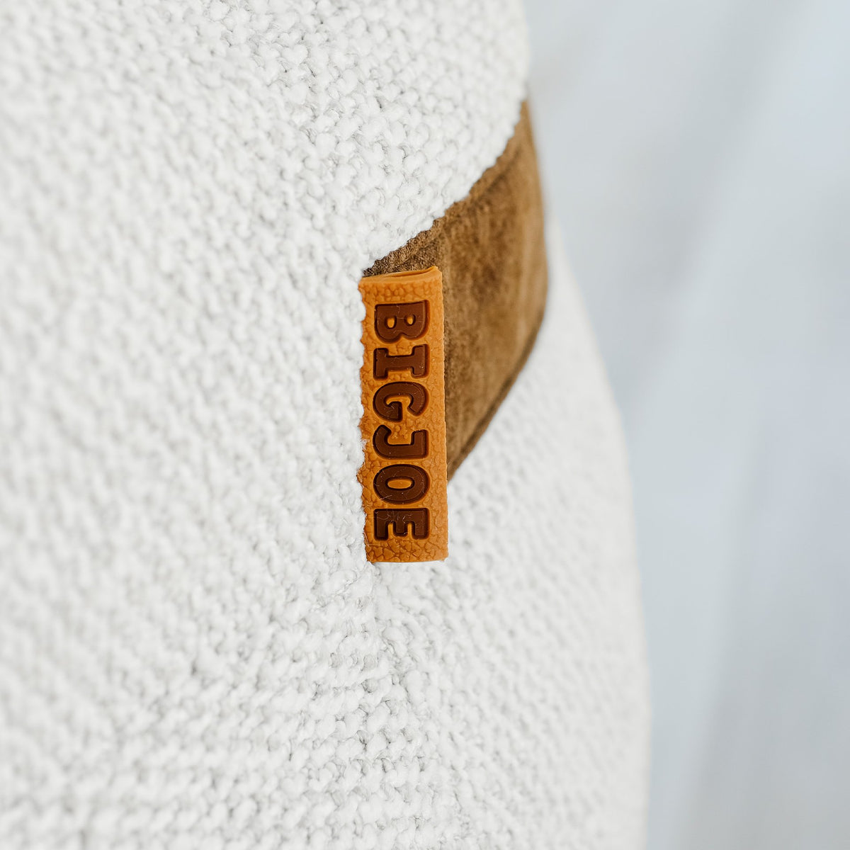 Close-up of a Big Joe logo on a textured white boucle beanbag  