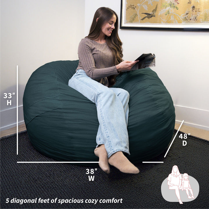 Woman sitting on a large green bean bag chair with measurements displayed. #color_deep-sea-velveteen