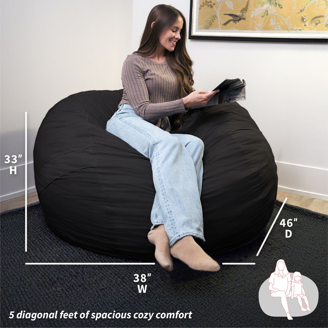 Woman sitting on a black bean bag chair with measurements displayed #color_black-brushed-denim