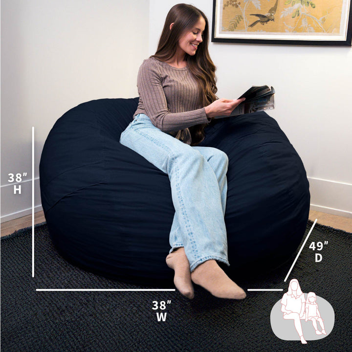 Woman sitting on a navy bean bag chair with measurements displayed #color_cobalt-brushed-denim