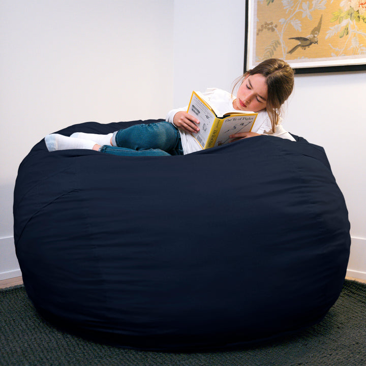 Person reading a book inside a large navy bean bag chair. #color_cobalt-brushed-denim