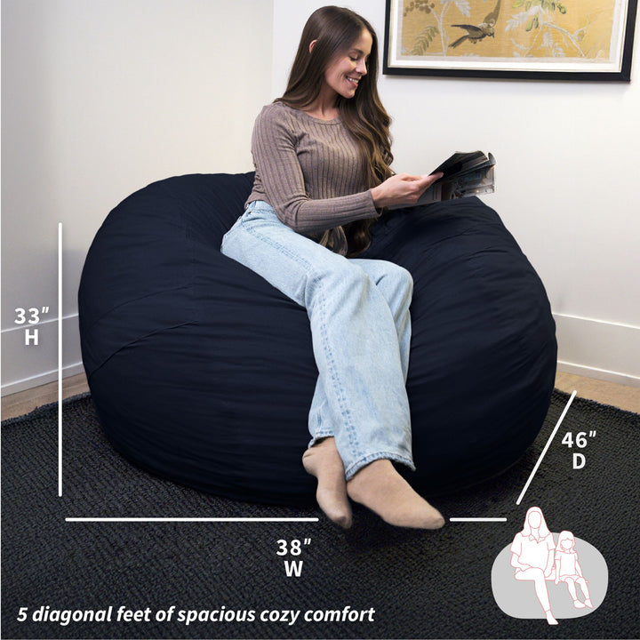 Woman sitting on a navy bean bag chair with dimensions displayed #color_cobalt-brushed-denim